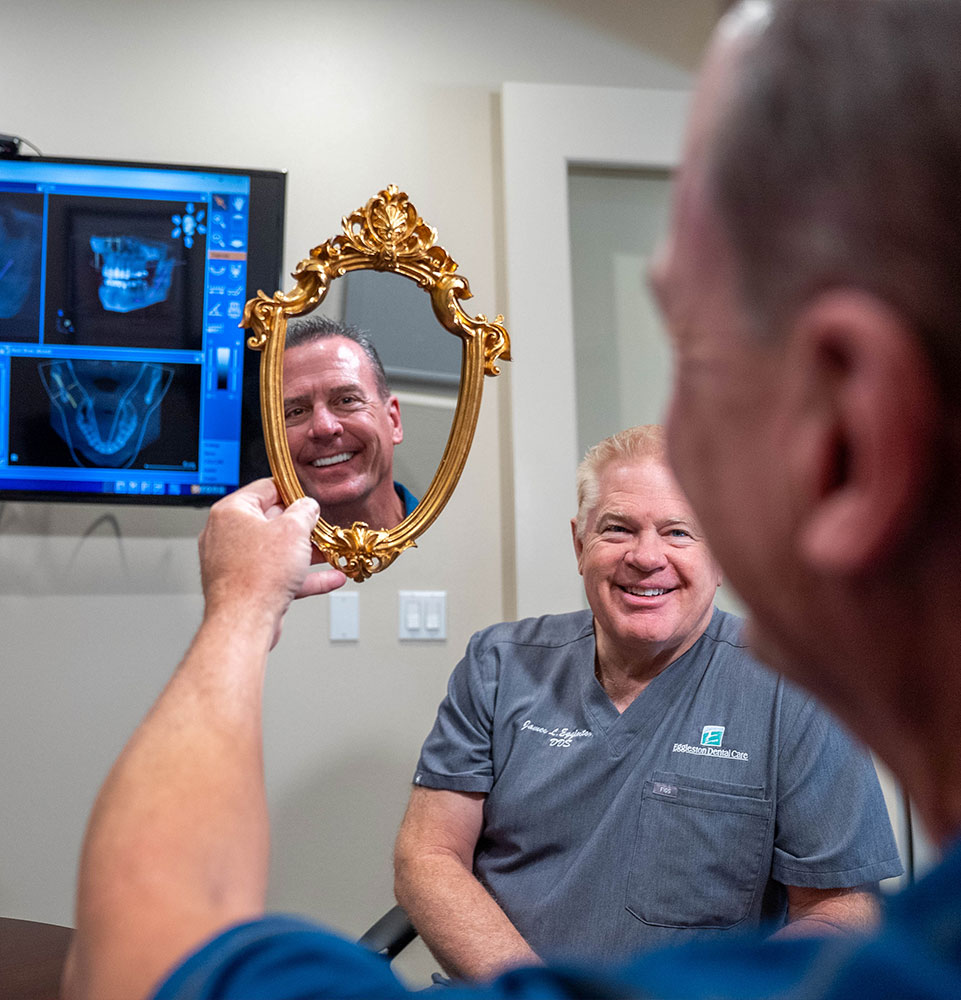 Dr. Eggleston smiling with a patient reviewing 3D dental imaging at Eggleston Dental Care